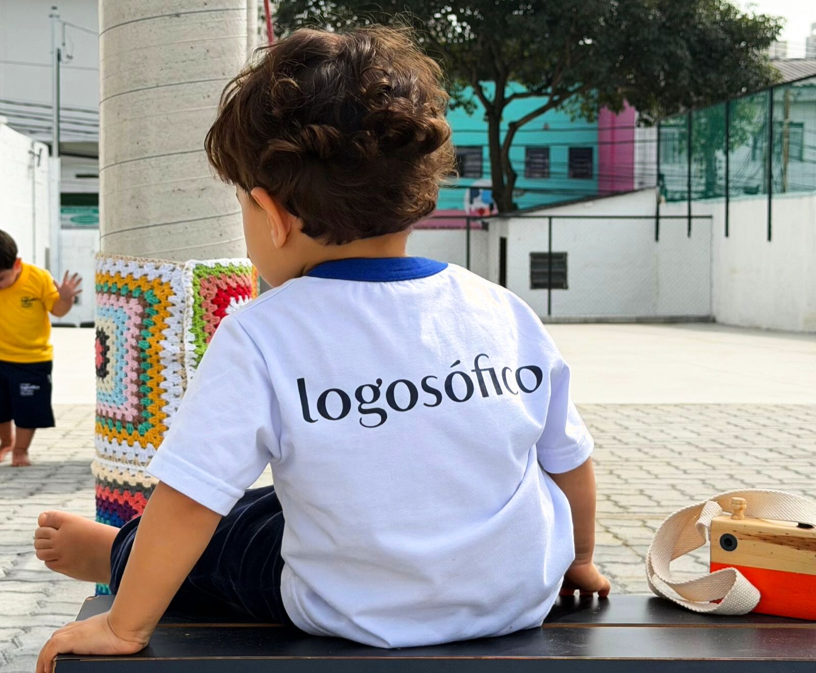 Aluno do Colégio Logosófico no pátio com camiseta da escola